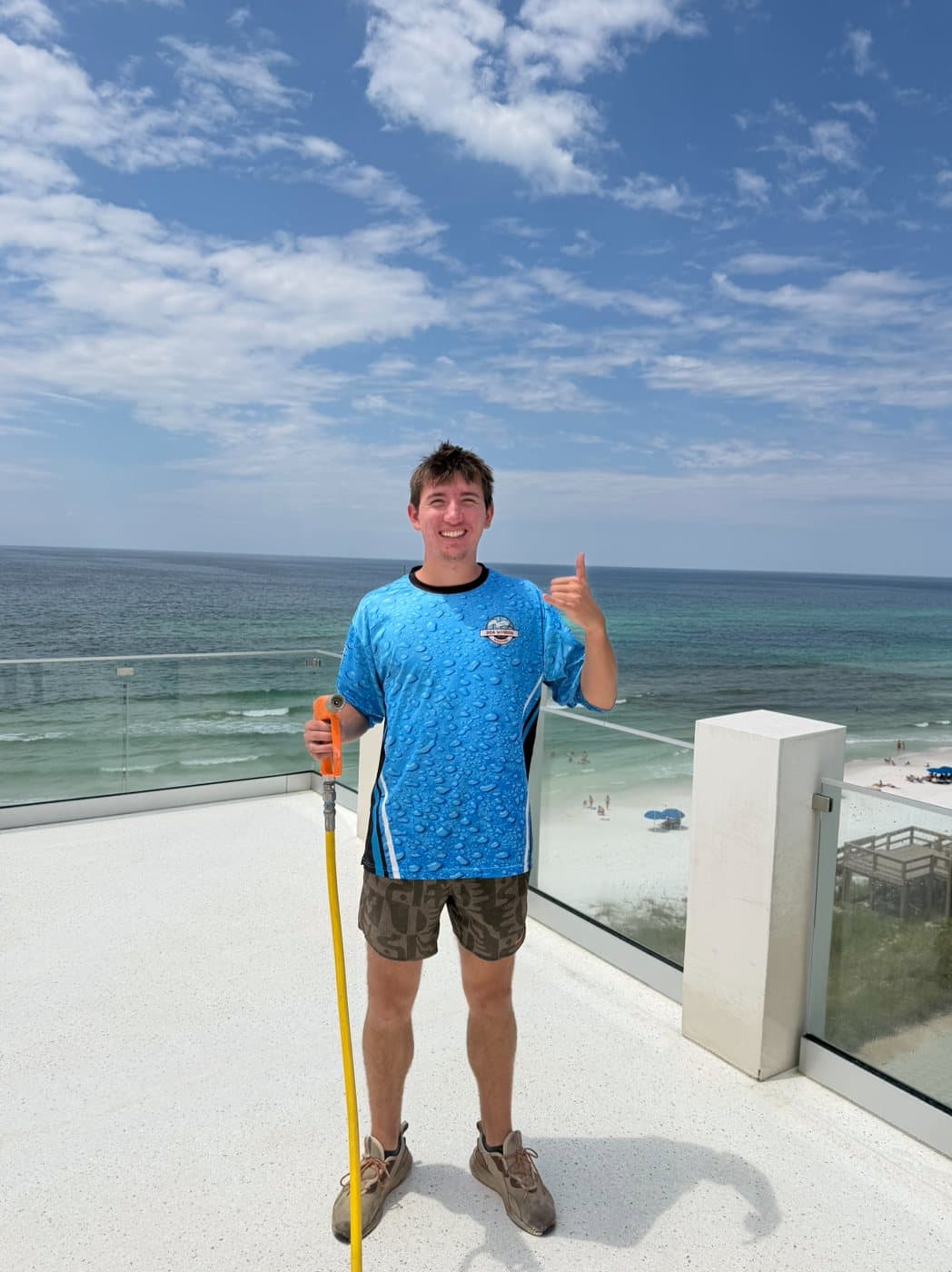 A 30A Window Washing crew member on a Gulf-front rooftop deck