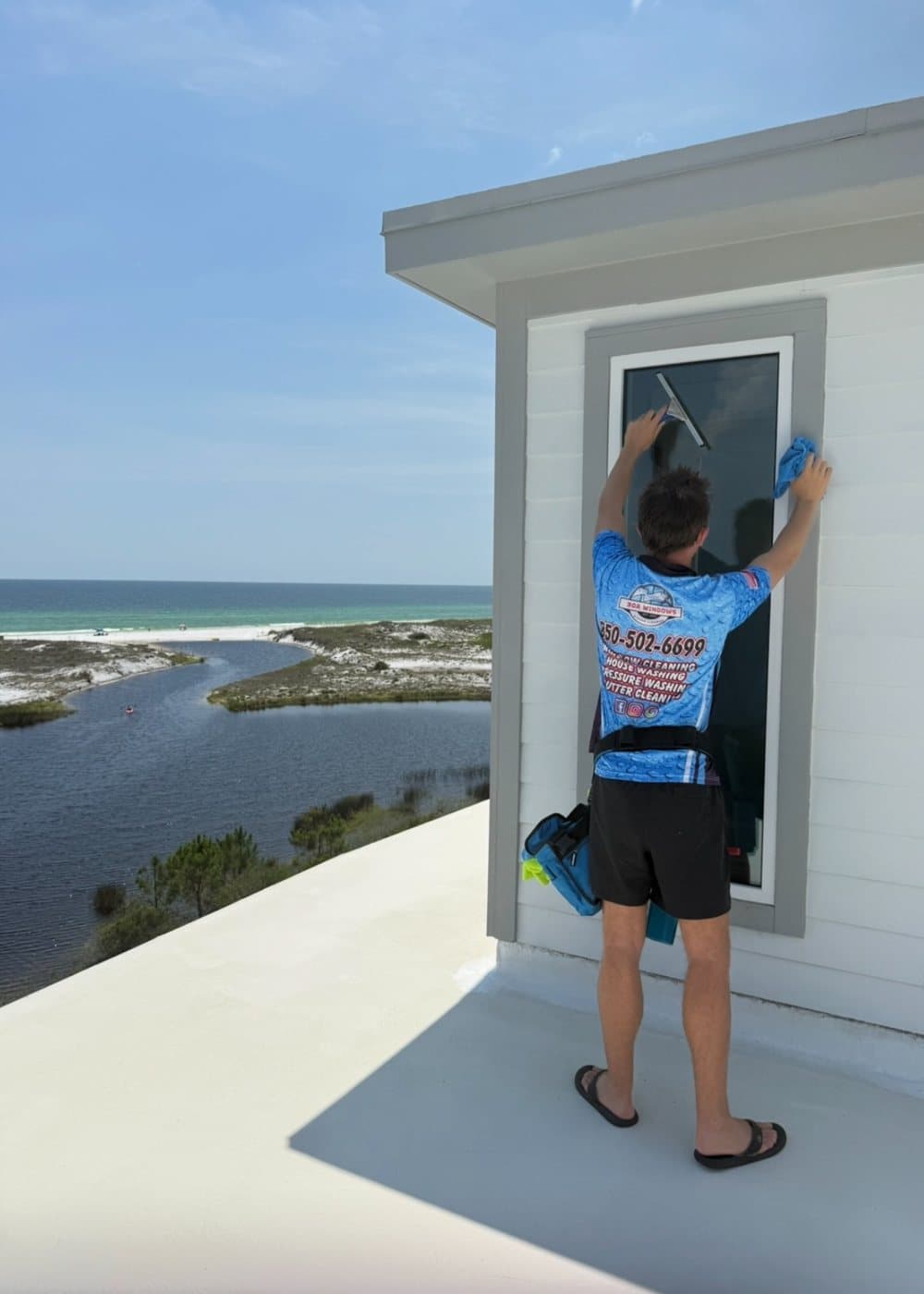 Hand-detailing a rooftop window above a coastal dune lake